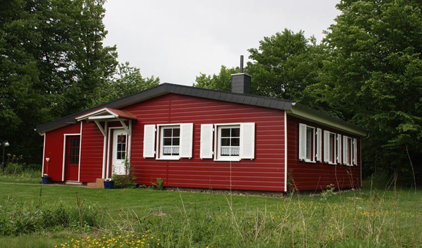 Ein Einfamilienhaus mit roter Fassade in schwedenoptik. Rote VinyPlus Fassadenpaneele.