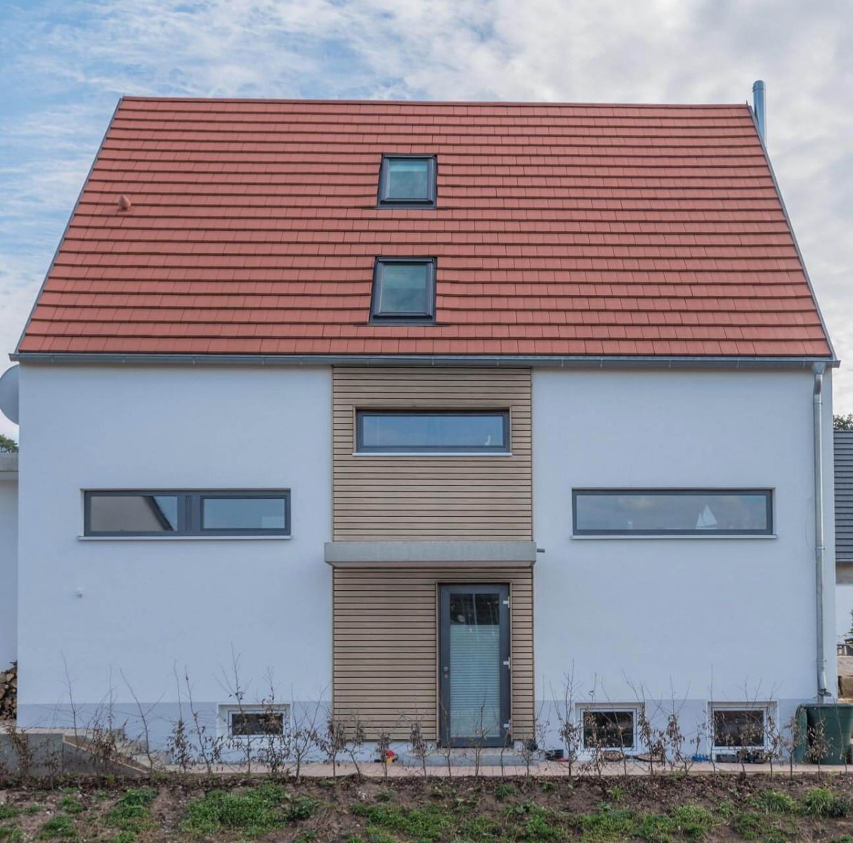 Ein Einfamilienhaus mit einer modernen Vorhangfassade in Rhombusoptik. Die schmalen Rhombusleisten bestehen aus recyceltem Hart-PVC und sind mit einer UV-beständigen Strukturfolie beschichtet