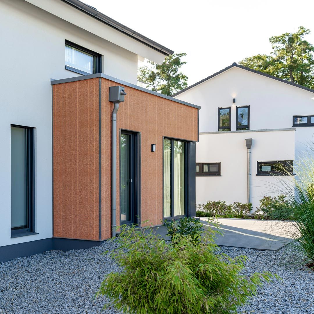 Moderne Einfamilienhäuser. Die Fassadenverkleidung in senkrechter Verlegung besteht aus einer Kombination von den Farben Jura Pine und Kitami Oak